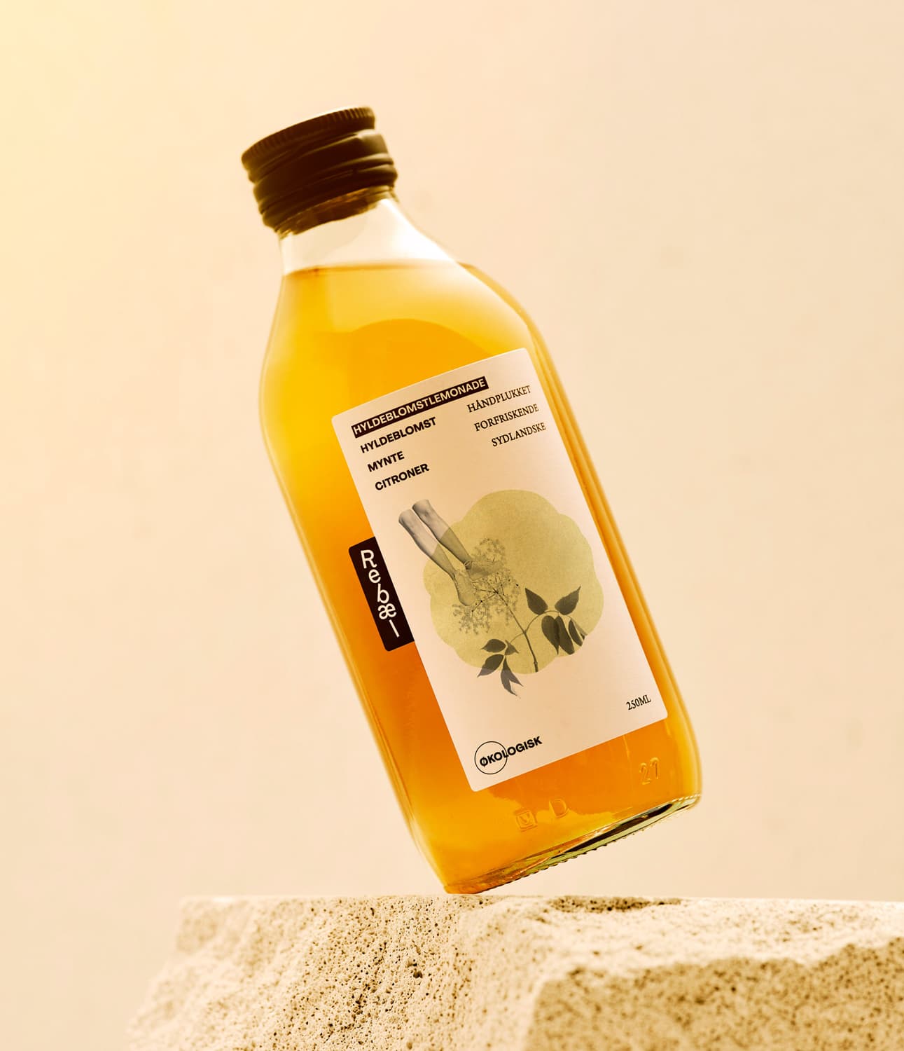 A bottle of Rebel balancing on the tip