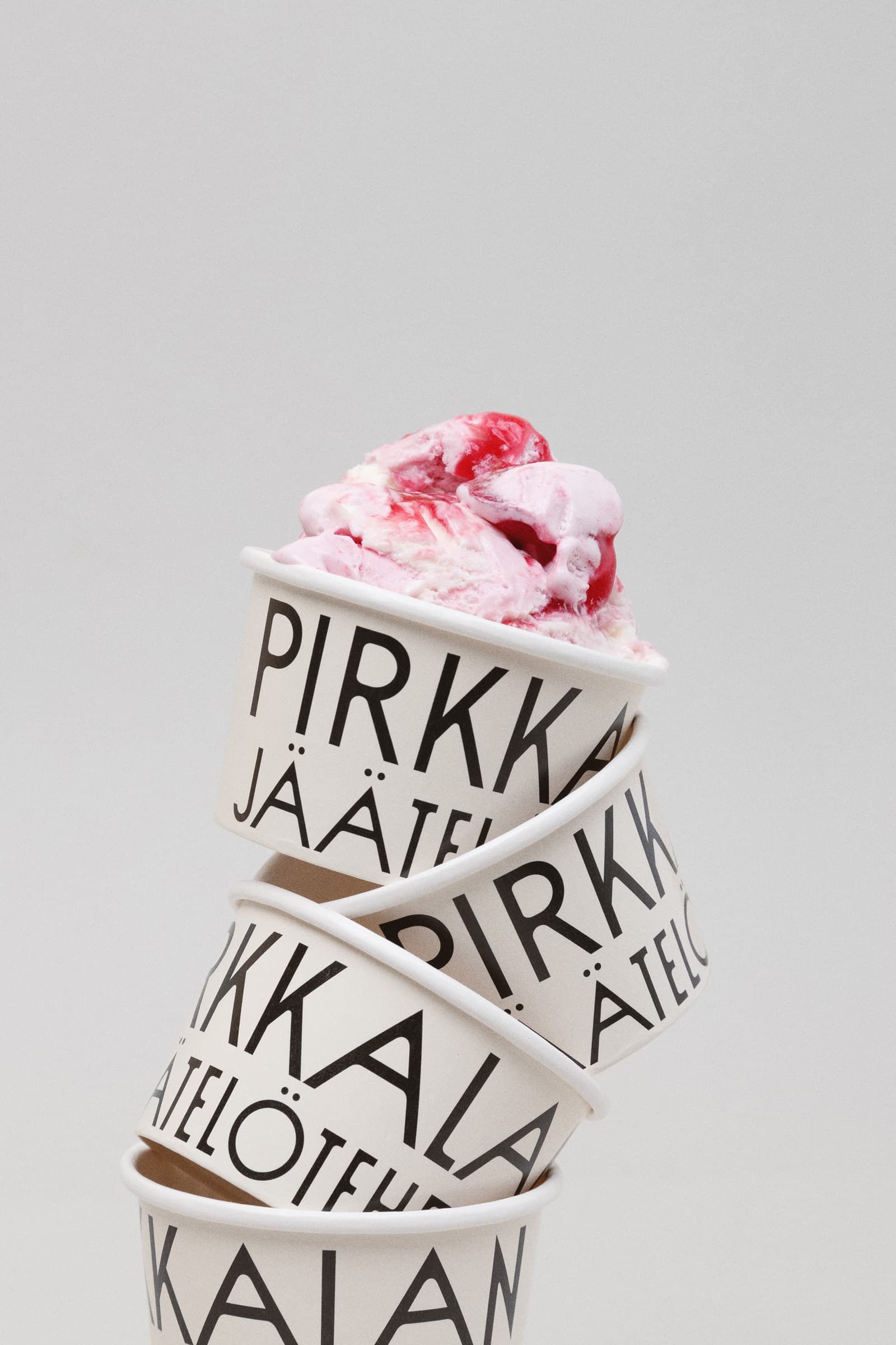 Pirkkalan ice cream containers stacked on top of each other with a scoop of ice cream.