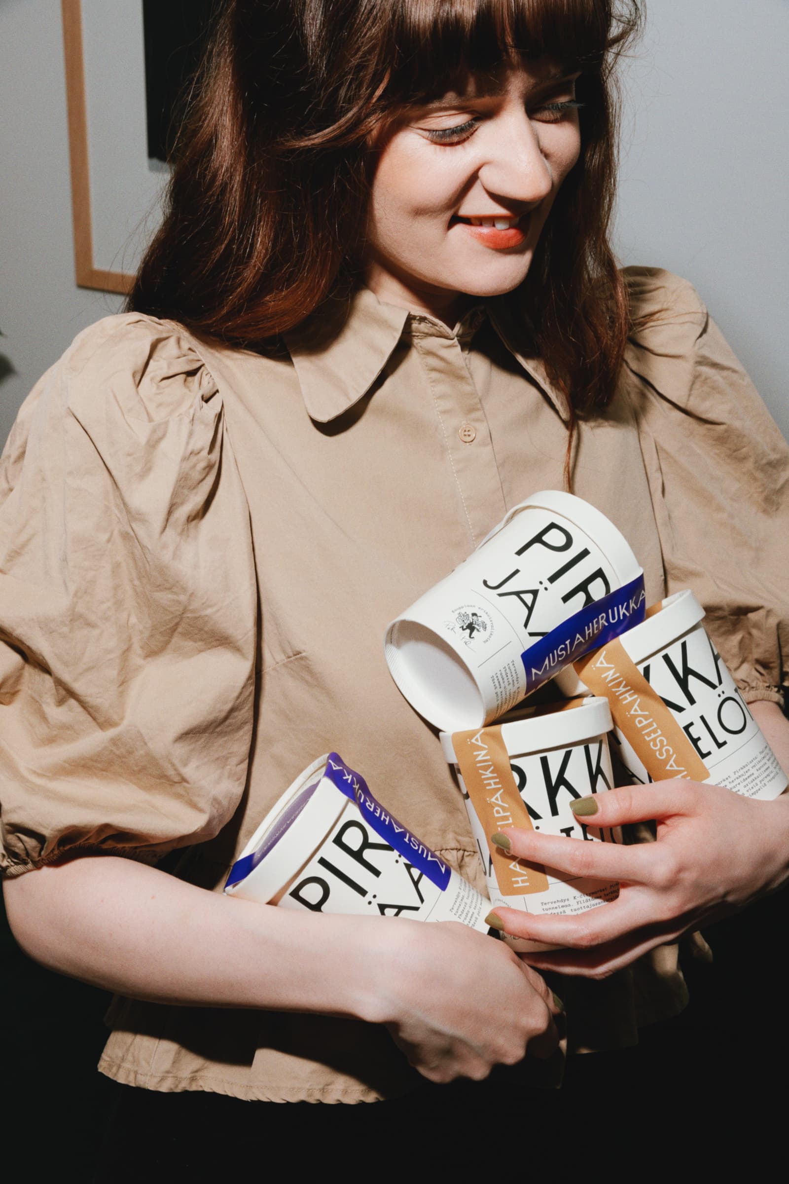 Woman holding four cups of ice cream from Pirkkalan