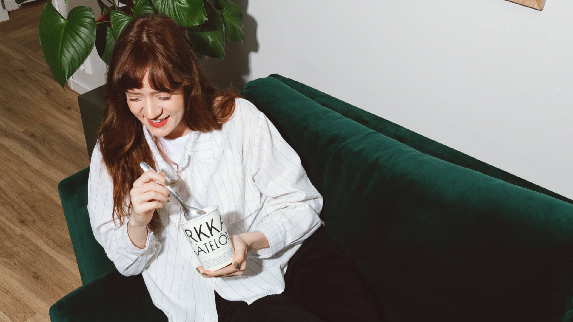 Woman sitting on a couch holding a cup of ice cream from Pirkkalan