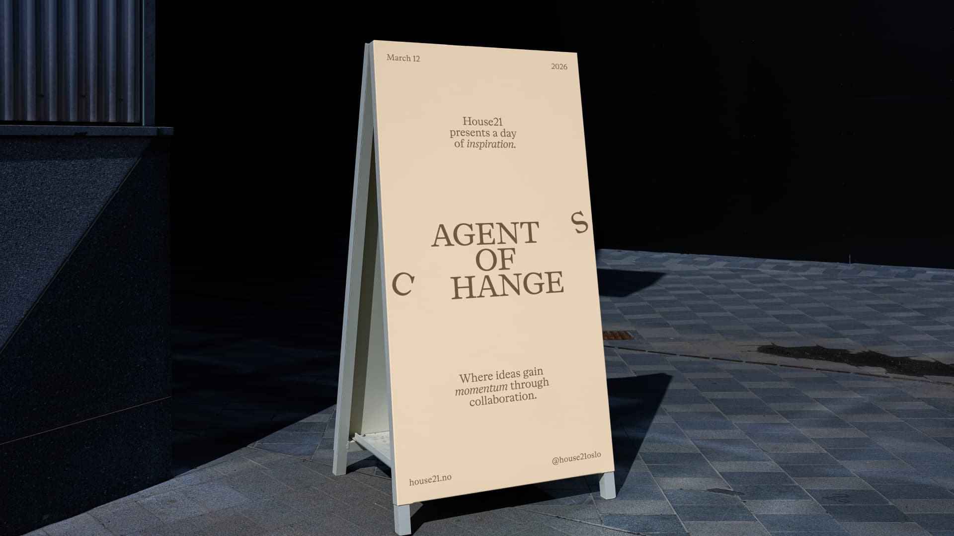 Vertical view of the A-frame sidewalk sign for the House21 event 'Agent of Change', dated March 12, 2026, on a stone pavement.