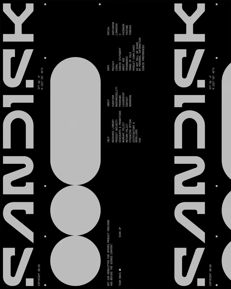 Dark website footer with SanDisk typography arranged vertically, geometric shapes, and editorial content in the centre