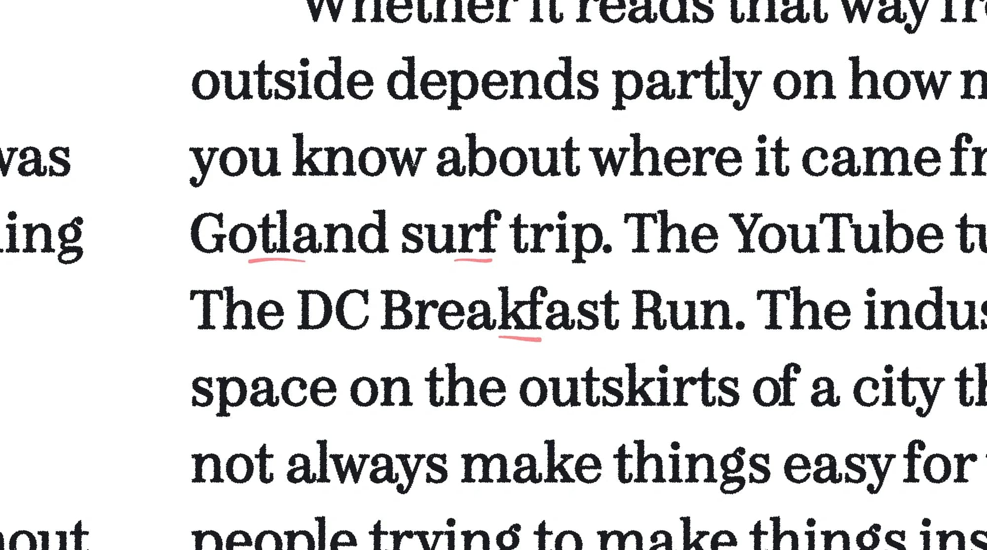 Close-up of proofread magazine copy with red underline marks flagging phrases such as 'Gotland surf trip' and 'The DC Breakfast Run' for editorial review.