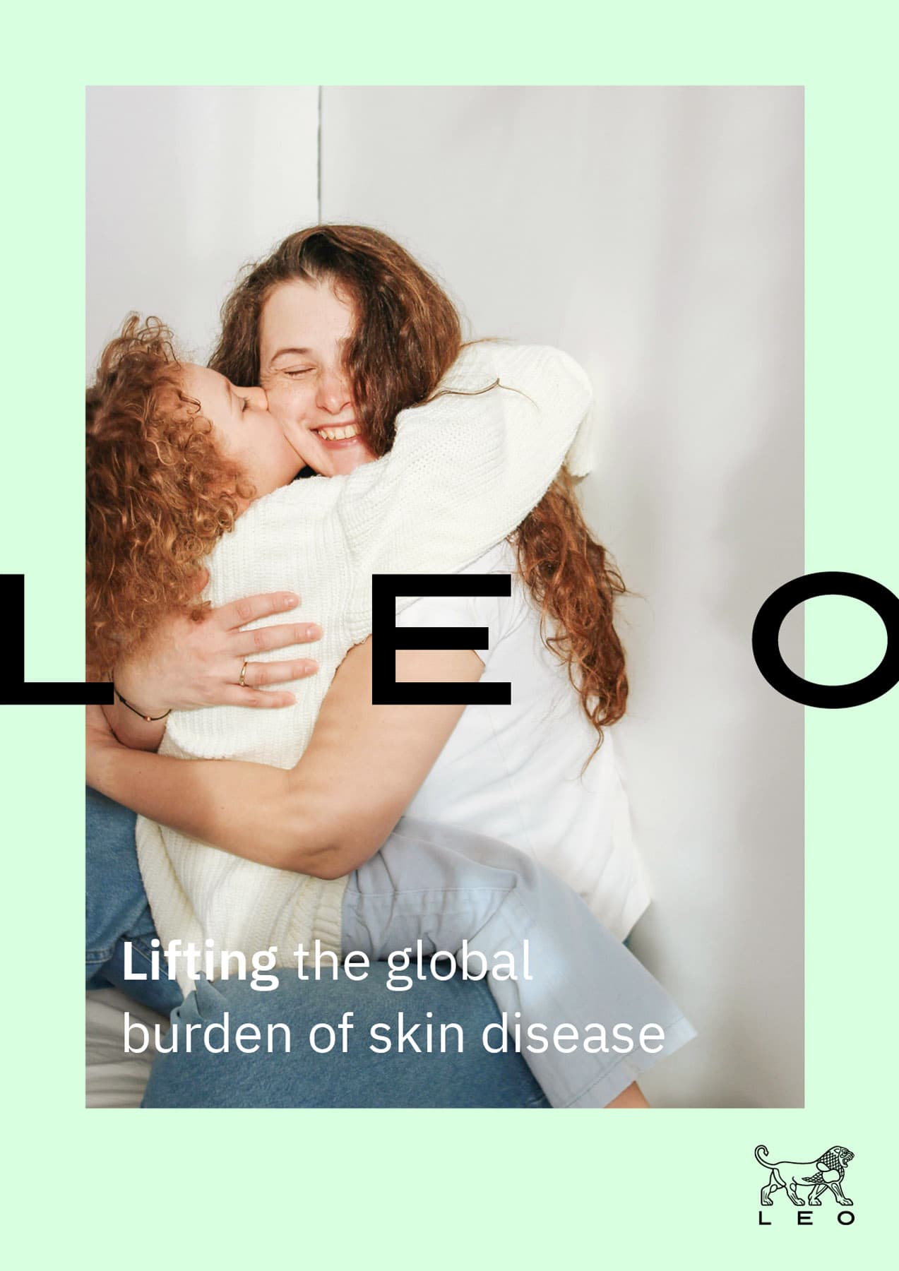 LEO Pharma brand ad: Two women warmly embracing and smiling. LEO logotype and tagline 'Lifting the global burden of skin disease' on mint green background.