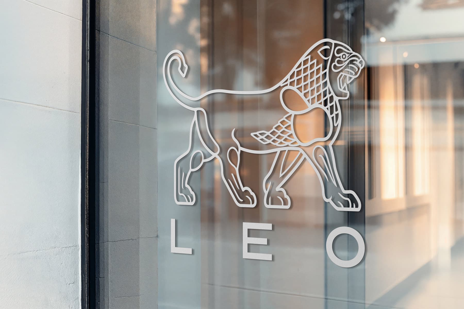 LEO Pharma's lion logo as frosted metal signage mounted on the glass facade at the company's office entrance.