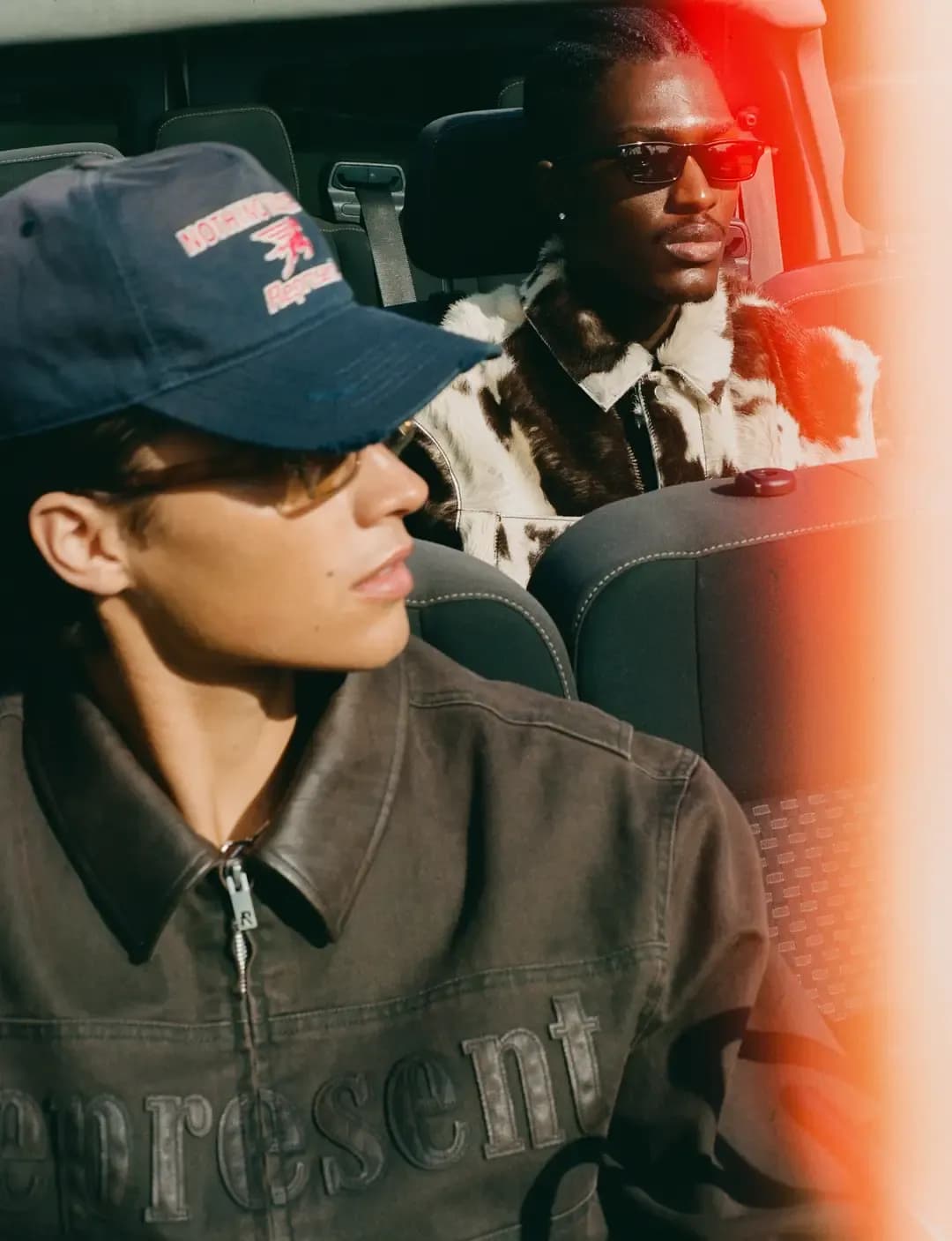 Two men sitting in a convertible wearing clothes bought at UK fashion brand Represent