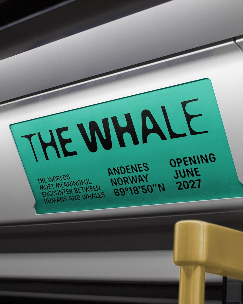 The Whale ad card in a train carriage overhead rail with opening info