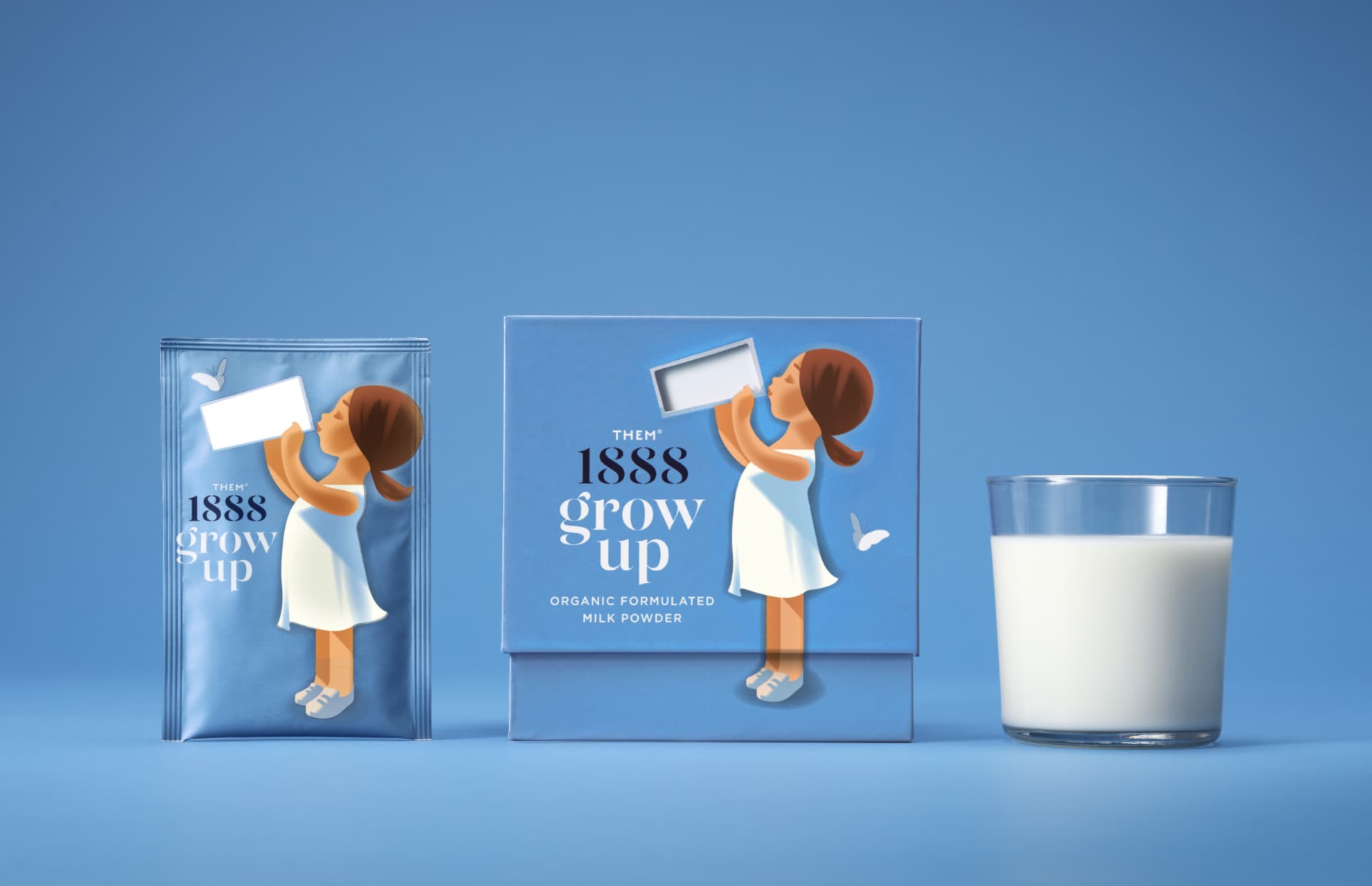 A sachet and package from Them 1888 standing next to a glass of milk