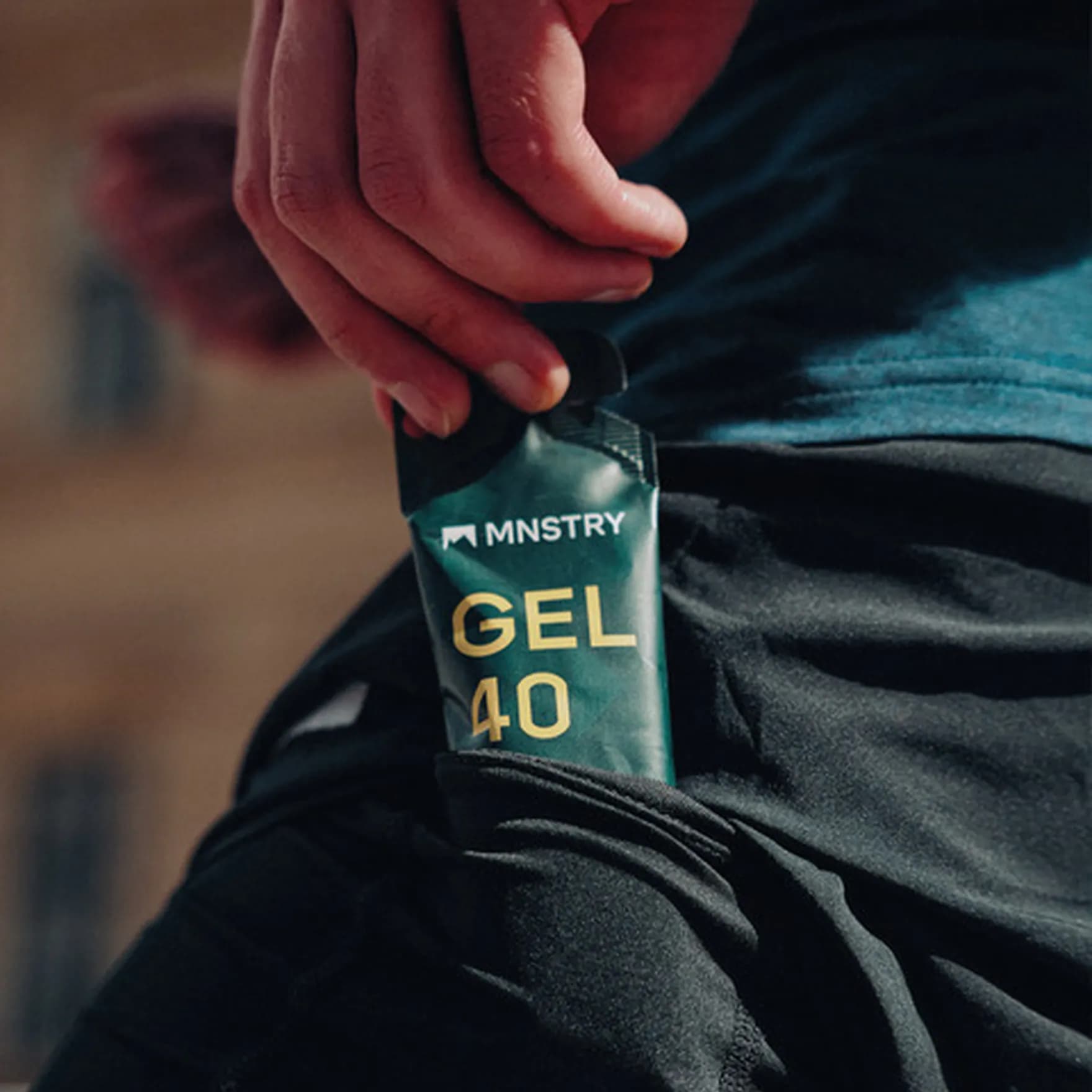 A bicyclist grabbing a MNSTRY gel from his pocket