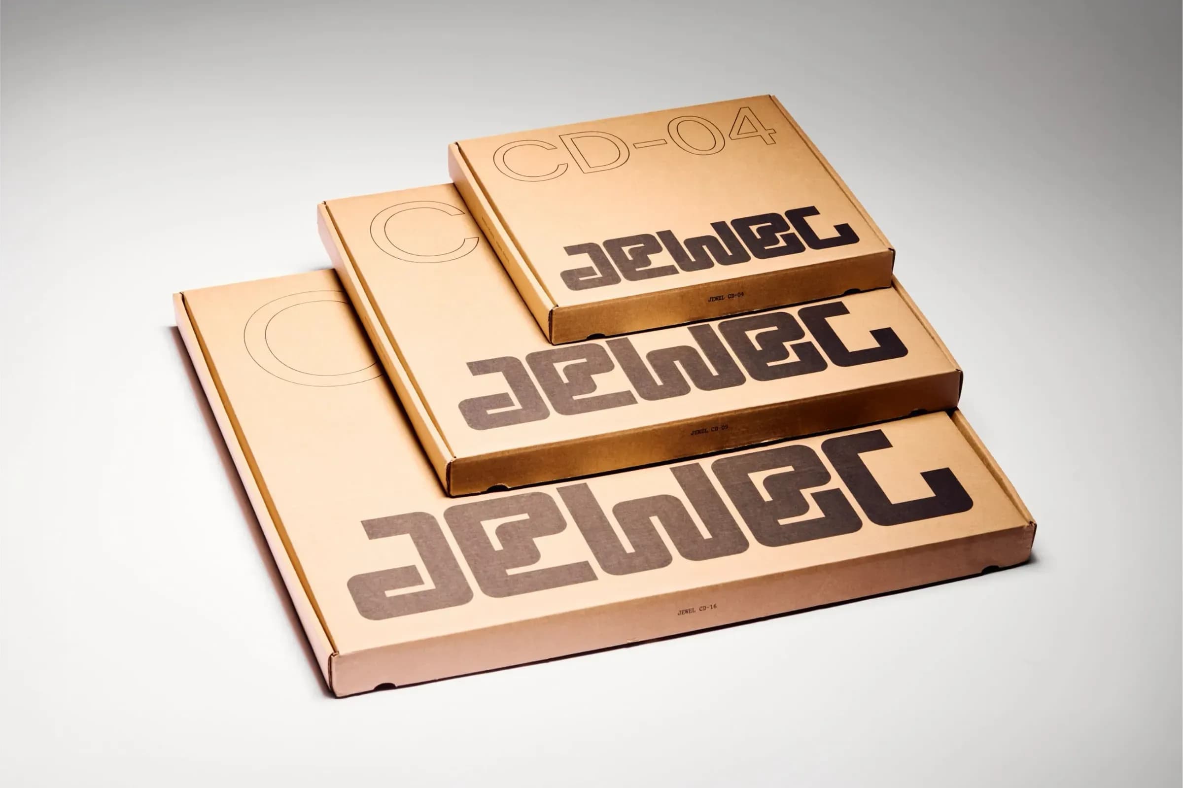 Three cardboard boxes of different sizes stacked on top of each other. Branded with the name Jewel.