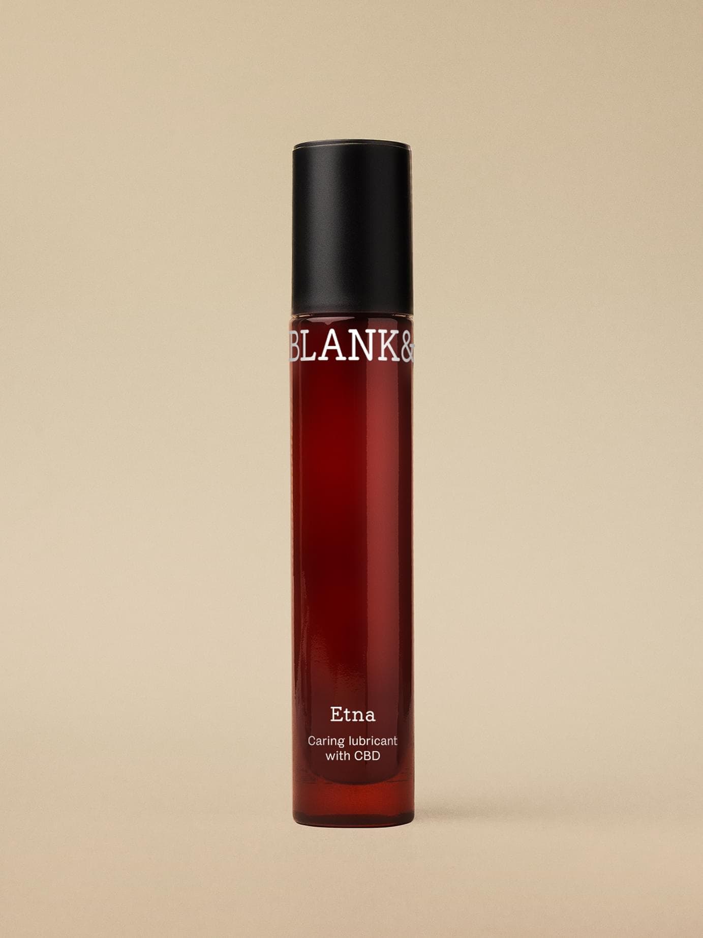 Blank& Etna bottle with black screw cap, a caring lubricant with CBD, shot standing against a beige backdrop.